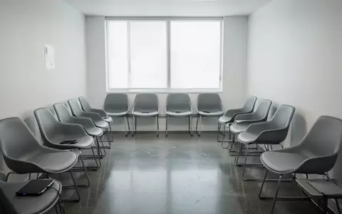 Leeres, minimalistisches Wartezimmer in einer modernen Arztpraxis mit grauen Stühlen und hellem Tageslicht. - Foto: über boerse-global.de