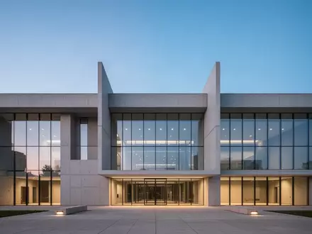 Moderne Fassade eines Verwaltungsgebäudes in der Dämmerung mit klaren architektonischen Linien und Glasflächen. - Foto: über boerse-global.de