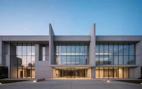 Moderne Fassade eines Verwaltungsgebäudes in der Dämmerung mit klaren architektonischen Linien und Glasflächen. - Foto: über boerse-global.de