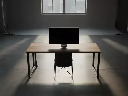 Ein minimalistischer, leerer Arbeitsplatz mit einem ausgeschalteten Monitor in einem schlichten, natürlich beleuchteten Raum. - Foto: über boerse-global.de