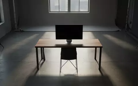 Ein minimalistischer, leerer Arbeitsplatz mit einem ausgeschalteten Monitor in einem schlichten, natürlich beleuchteten Raum. - Foto: über boerse-global.de
