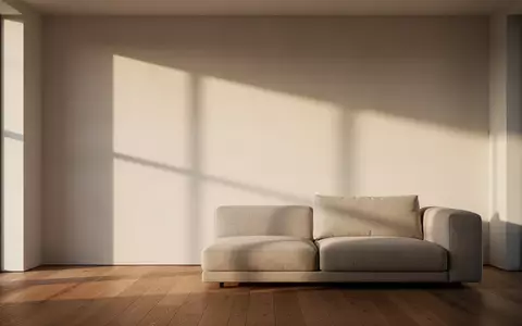 Ein minimalistisch gestalteter, lichtdurchfluteter Wohnraum mit schlichtem Sofa und klaren architektonischen Linien. - Foto: über boerse-global.de