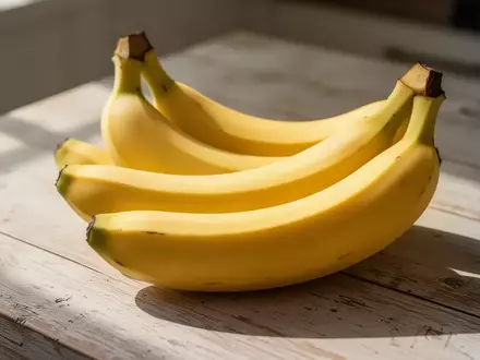 Frische Bananen auf einem hellen Holztisch im morgendlichen Sonnenlicht. - Foto: über boerse-global.de