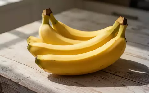 Frische Bananen auf einem hellen Holztisch im morgendlichen Sonnenlicht. - Foto: über boerse-global.de