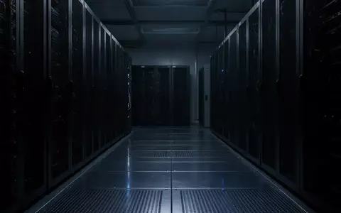 Ein minimalistisch beleuchteter, dunkler Serverraum mit metallischen Bodenplatten und kühlen Lichtreflexen. - Foto: über boerse-global.de