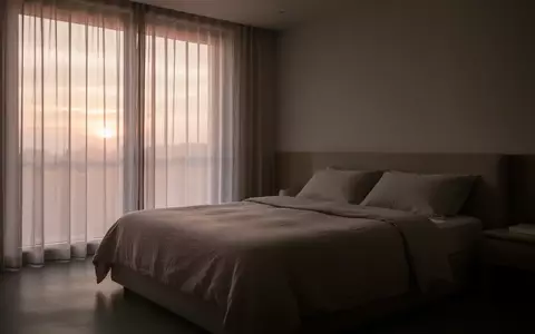 Ein minimalistisch eingerichtetes Schlafzimmer in ruhigem Morgenlicht, das eine Atmosphäre von erholsamem Schlaf vermittelt. - Foto: über boerse-global.de