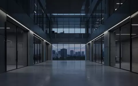 Ein minimalistisches, modernes Bürogebäude in der Dämmerung mit kühler Beleuchtung und klaren architektonischen Linien. - Foto: über boerse-global.de