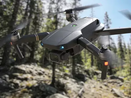 Eine technologisch fortschrittliche Drohne fliegt über ein unwegsames Waldgebiet zur Demonstration autonomer Navigation. - Foto: über boerse-global.de