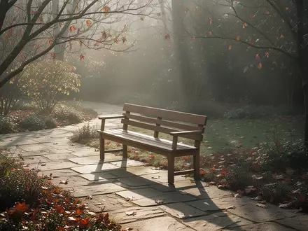 Eine leere Holzbank in einem ruhigen Garten im Herbstlicht, die eine Atmosphäre der Einkehr und Reflexion vermittelt. - Foto: über boerse-global.de