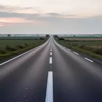 Eine leere, asphaltierte Landstraße in einer ruhigen Landschaft bei Dämmerung. - Foto: über boerse-global.de