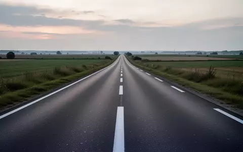 Eine leere, asphaltierte Landstraße in einer ruhigen Landschaft bei Dämmerung. - Foto: über boerse-global.de