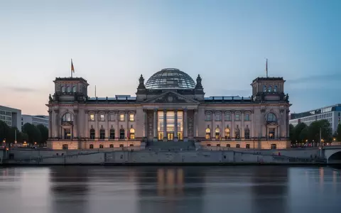 Das Reichstagsgebäude in Berlin bei Dämmerung, aufgenommen von der Spree aus mit Fokus auf die Architektur. - Foto: über boerse-global.de