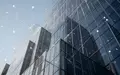 Moderne Glasfassade eines Bürogebäudes bei klarem Himmel als Symbol für globale Finanzinfrastruktur. - Foto: über boerse-global.de