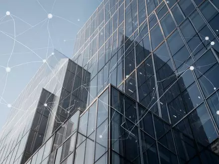 Moderne Glasfassade eines Bürogebäudes bei klarem Himmel als Symbol für globale Finanzinfrastruktur. - Foto: über boerse-global.de