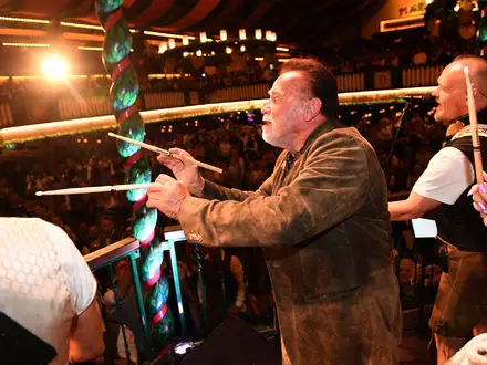 «Terminator» Arnold Schwarzenegger dirigiert im Marstall-Festzelt. - Foto: Felix Hörhager/dpa