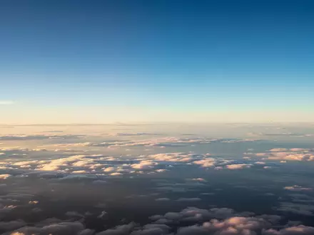 Ein weiter, klarer Himmel über einer dichten Wolkendecke, der die Atmosphäre in der Reiseflughöhe darstellt. - Foto: über boerse-global.de