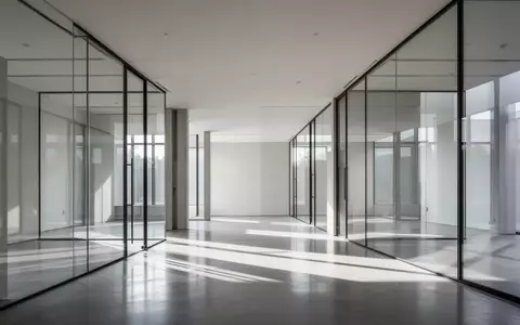 Ein minimalistisch gestalteter Innenraum mit Glaswänden und hellem Tageslicht in einem modernen Gebäude. - Foto: über boerse-global.de