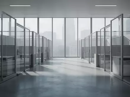 Ein minimalistisch gestaltetes, leeres Büro mit Glaswänden und natürlichem Lichteinfall, das eine Atmosphäre von Überwachung und Ordnung vermittelt. - Foto: über boerse-global.de