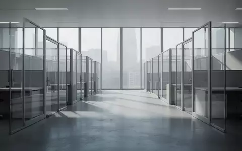 Ein minimalistisch gestaltetes, leeres Büro mit Glaswänden und natürlichem Lichteinfall, das eine Atmosphäre von Überwachung und Ordnung vermittelt. - Foto: über boerse-global.de