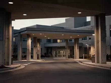Leere Zufahrt eines Krankenhauses in der Dämmerung mit architektonischen Betonsäulen. - Foto: über boerse-global.de