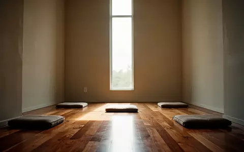 Ein minimalistischer Meditationsraum mit einfallendem Tageslicht und schlichten Sitzkissen auf einem Holzboden. - Foto: über boerse-global.de