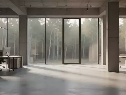Ein minimalistischer, moderner Industrieraum mit poliertem Betonboden und natürlichem Licht, das durch große Fenster fällt. - Foto: über boerse-global.de