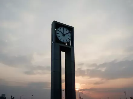 Minimalistische Silhouette eines modernen Uhrturms vor einem bewölkten Morgenhimmel als Symbol für Zeit und Vorsorge. - Foto: über boerse-global.de