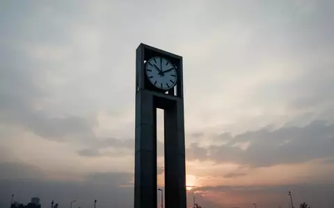 Minimalistische Silhouette eines modernen Uhrturms vor einem bewölkten Morgenhimmel als Symbol für Zeit und Vorsorge. - Foto: über boerse-global.de