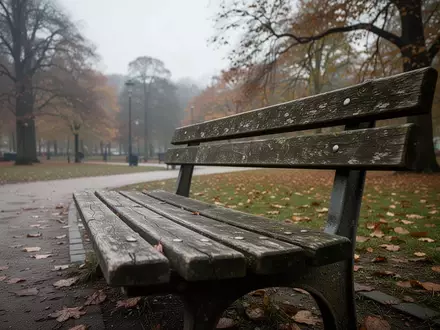 Eine leere, verwitterte Parkbank in einem sächsischen Park an einem bewölkten Tag. - Foto: über boerse-global.de