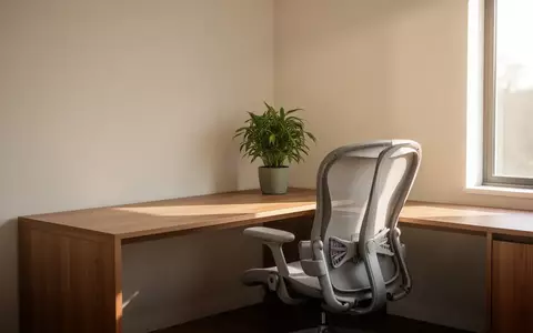 Ein minimalistisch eingerichteter, heller Arbeitsplatz in einem Wohnraum mit einer Pflanze und natürlichem Tageslicht. - Foto: über boerse-global.de