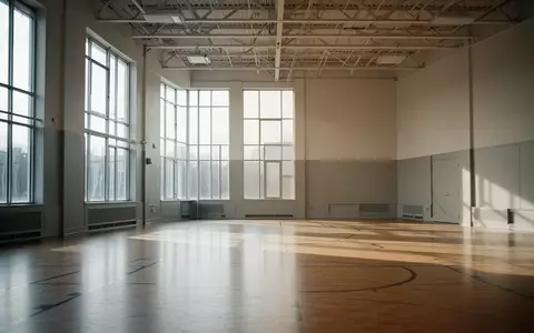 Ein heller, leerer Gymnastikraum mit Holzboden und einfallendem Tageslicht in einer Schule. - Foto: über boerse-global.de