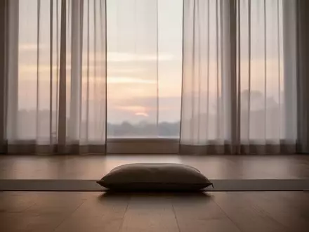 Ein minimalistischer, ruhiger Raum bei Tagesanbruch mit weichem, diffusem Licht und einem einzelnen Meditationskissen am Boden. - Foto: über boerse-global.de