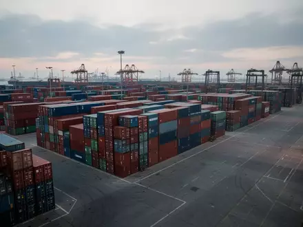 Ein moderner Fracht-Containerhafen mit gestapelten Containern bei Dämmerung - Foto: über boerse-global.de