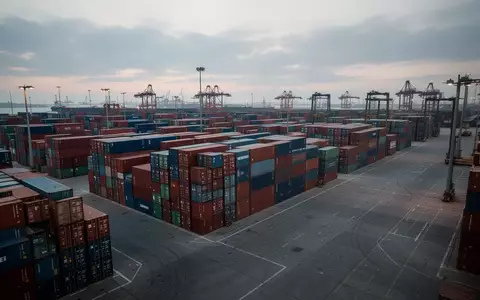 Ein moderner Fracht-Containerhafen mit gestapelten Containern bei Dämmerung - Foto: über boerse-global.de