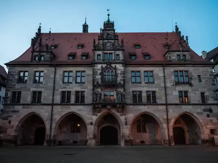 Historische Fassade eines deutschen Rathauses in der Dämmerung mit Fokus auf Architektur und Steinmauerwerk. - Foto: über boerse-global.de