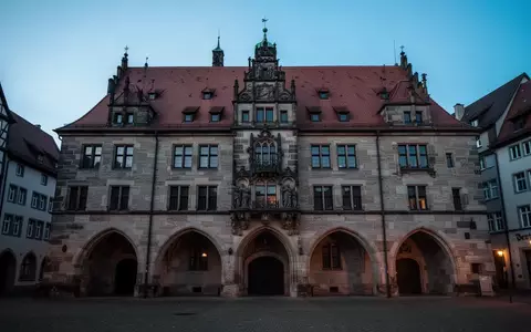 Historische Fassade eines deutschen Rathauses in der Dämmerung mit Fokus auf Architektur und Steinmauerwerk. - Foto: über boerse-global.de
