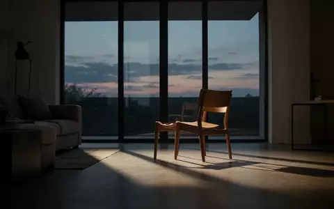 Ein leerer Stuhl in einem modern eingerichteten Wohnzimmer bei Dämmerlicht, der eine Atmosphäre der Isolation und des Verlusts vermittelt. - Foto: über boerse-global.de