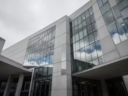 Moderne Fassade eines Regierungsgebäudes aus Glas und Beton bei bewölktem Himmel. - Foto: über boerse-global.de