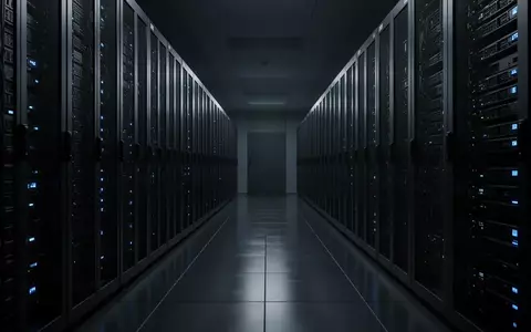 Dunkler, moderner Serverraum mit langen Reihen dunkler Serverschränke und schwachen blauen Statusleuchten. - Foto: über boerse-global.de