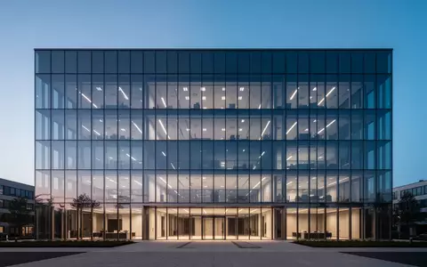 Ein modernes, minimalistisches Bürogebäude aus Glas in der Abenddämmerung. - Foto: über boerse-global.de