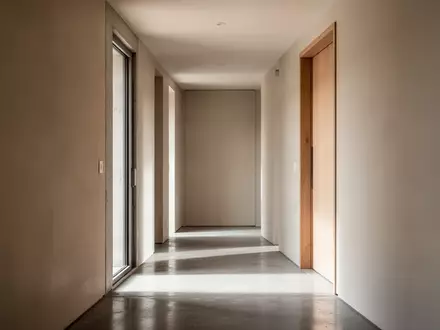 Ein minimalistischer Flur in einem modernen Wohnhaus mit neutralen Wänden und weichem Tageslicht. - Foto: über boerse-global.de