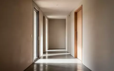 Ein minimalistischer Flur in einem modernen Wohnhaus mit neutralen Wänden und weichem Tageslicht. - Foto: über boerse-global.de