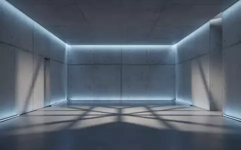 Ein minimalistischer, architektonisch gestalteter Raum mit indirekter blauer Beleuchtung und klaren geometrischen Schatten. - Foto: über boerse-global.de