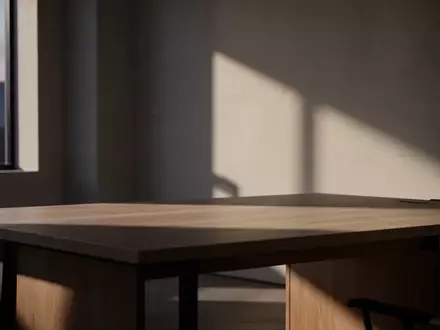 Minimalistischer, leerer Arbeitsplatz bei Dämmerlicht mit sanftem Lichteinfall und geometrischen Schatten. - Foto: über boerse-global.de