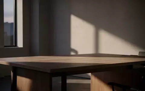 Minimalistischer, leerer Arbeitsplatz bei Dämmerlicht mit sanftem Lichteinfall und geometrischen Schatten. - Foto: über boerse-global.de