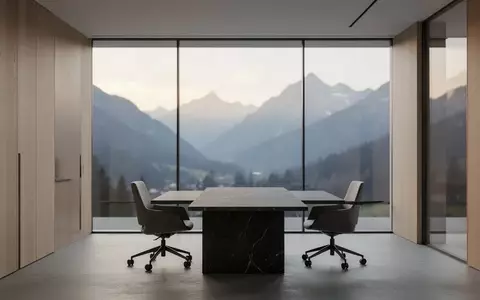 Ein minimalistisches, leeres Büro mit Blick auf eine Schweizer Berglandschaft bei Tagesanbruch. - Foto: über boerse-global.de