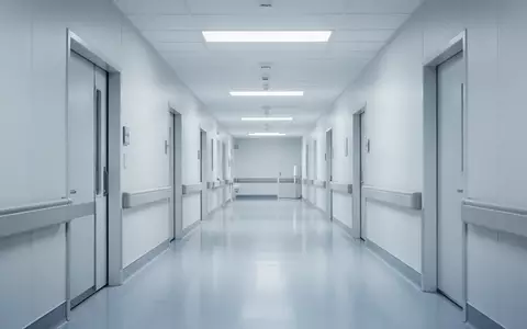 Ein steriler, menschenleerer Krankenhausflur mit einer minimalistischen Architektur und kühler Beleuchtung. - Foto: über boerse-global.de