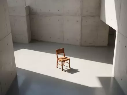Ein minimalistischer, lichtdurchfluteter Raum mit klaren architektonischen Linien und einem einzelnen leeren Stuhl. - Foto: über boerse-global.de
