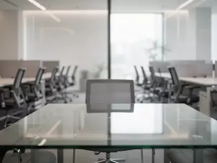 Ein minimalistisch gestalteter, leerer Büroarbeitsplatz mit einem modernen Konferenztisch und gedämpftem Licht. - Foto: über boerse-global.de