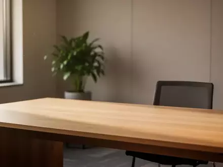 Ein heller, minimalistisch eingerichteter Büroraum mit einem leeren Schreibtisch und einer grünen Zimmerpflanze. - Foto: über boerse-global.de
